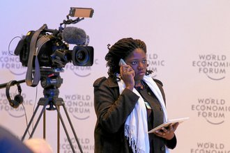 A television journalist talks on her cellphone at the World Economic Forum in Davos, Switzerland, in January 2014.