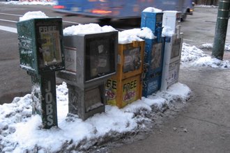 Snow on newspaper boxes