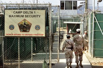 U.S. military guards walk within Camp Delta military-run prison, at the Guantanamo Bay U.S. Naval Base, Cuba, June 27, 2006