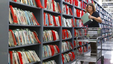 A California Department of Corrections and Rehabilitation employee retrieves incarcerated people's medical records at a facility in Sacramento.