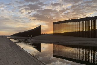 The sun sets above the U.S.-Mexico border wall, seen in Yuma, Ariz., Wednesday, June 9, 2021