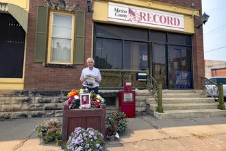 Eric Meyer, publisher of the Marion County Record, outside the newspaper's office with a memorial for his mother Joan, who died the day after police raided their home.
