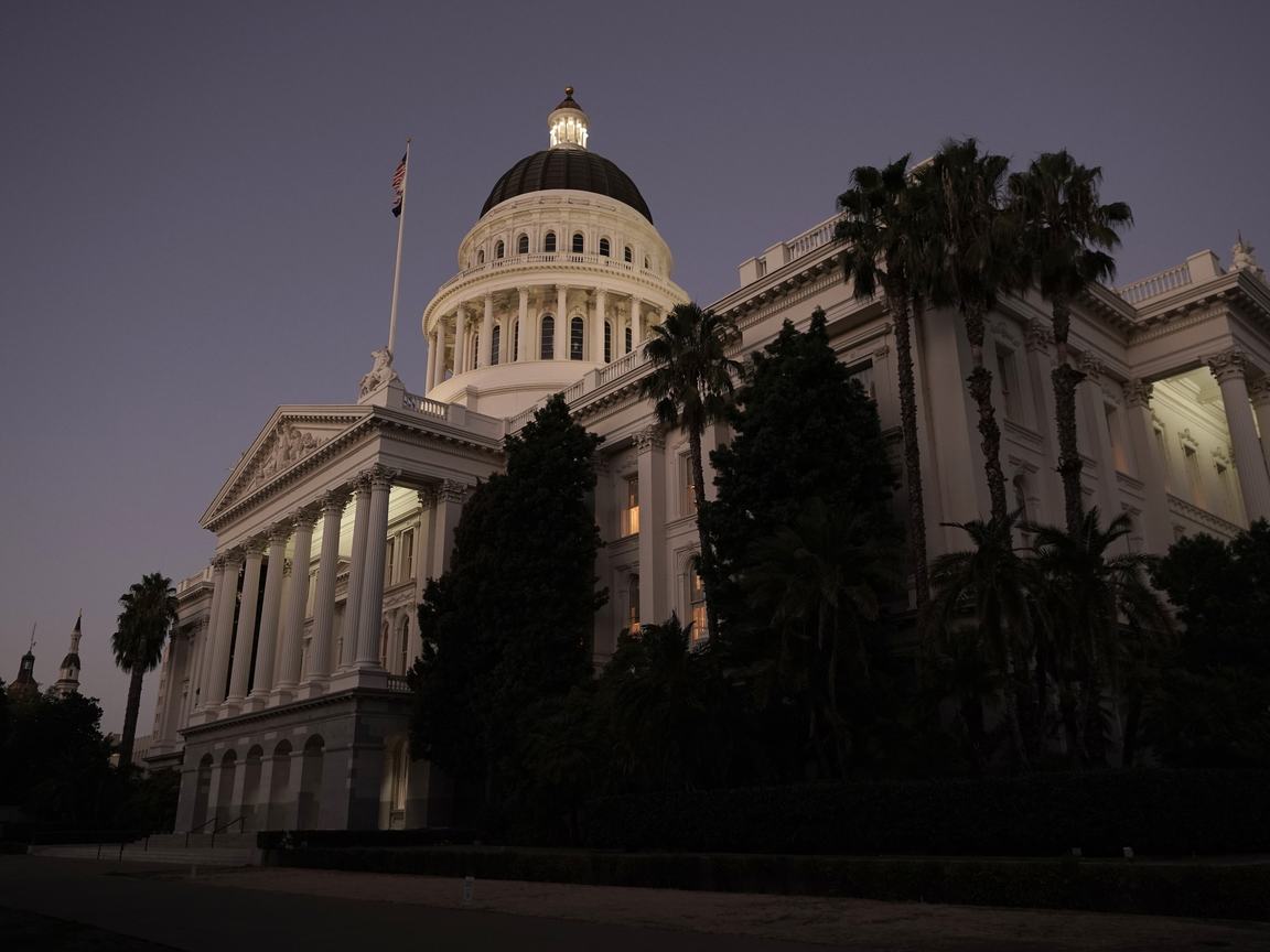 The California state capitol in Sacramento at night, with some lights visible in the windows