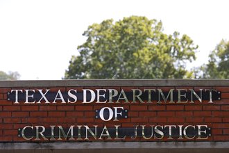 Texas Department of Criminal Justice signage is displayed outside the Huntsville "Walls" Unit in Huntsville, Texas.