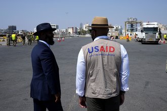 Members staff of U.S Aid stand as Gaza aid on a truck is about to enter a U.S ship, at the port of Larnaca, Cyprus, June 26, 2024
