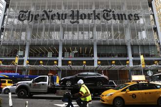 The entrance to the New York Times headquarters in New York City, with a stream of traffic passing in front of it.