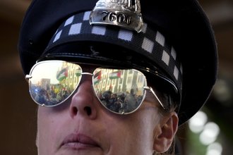 A police officer watches protesters march during a demonstration outside the Democratic National Convention on Aug. 21, 2024, in Chicago.