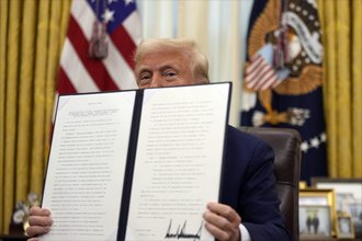 President Donald Trump, pictured in the Oval Office, holds the signed executive order mandating the release of JFK, MLK, and RFK assassination records.