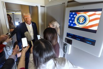 President Donald Trump talks to reporters aboard Air Force One in January.