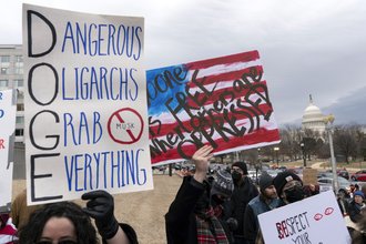 A photo of protesters outside of the Labor Department holding signs.