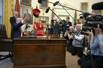 President Donald Trump throws a hat that reads “Trump Was Right About Everything” as he talks to reporters in the Oval Office in Washington, D.C., on Feb. 26, 2025.