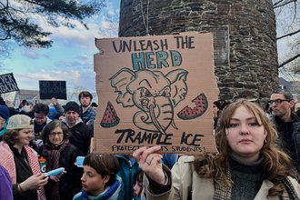 A protestor holds a sign reading "Unleash the heard, trample ICE"
