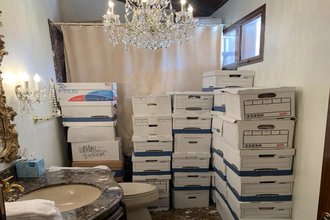 Several piles of storage boxes in a bathroom.