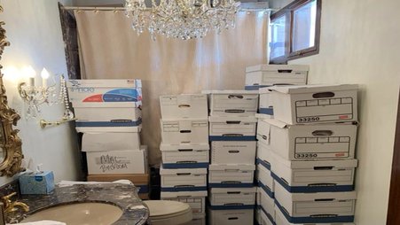 Several piles of storage boxes in a bathroom.