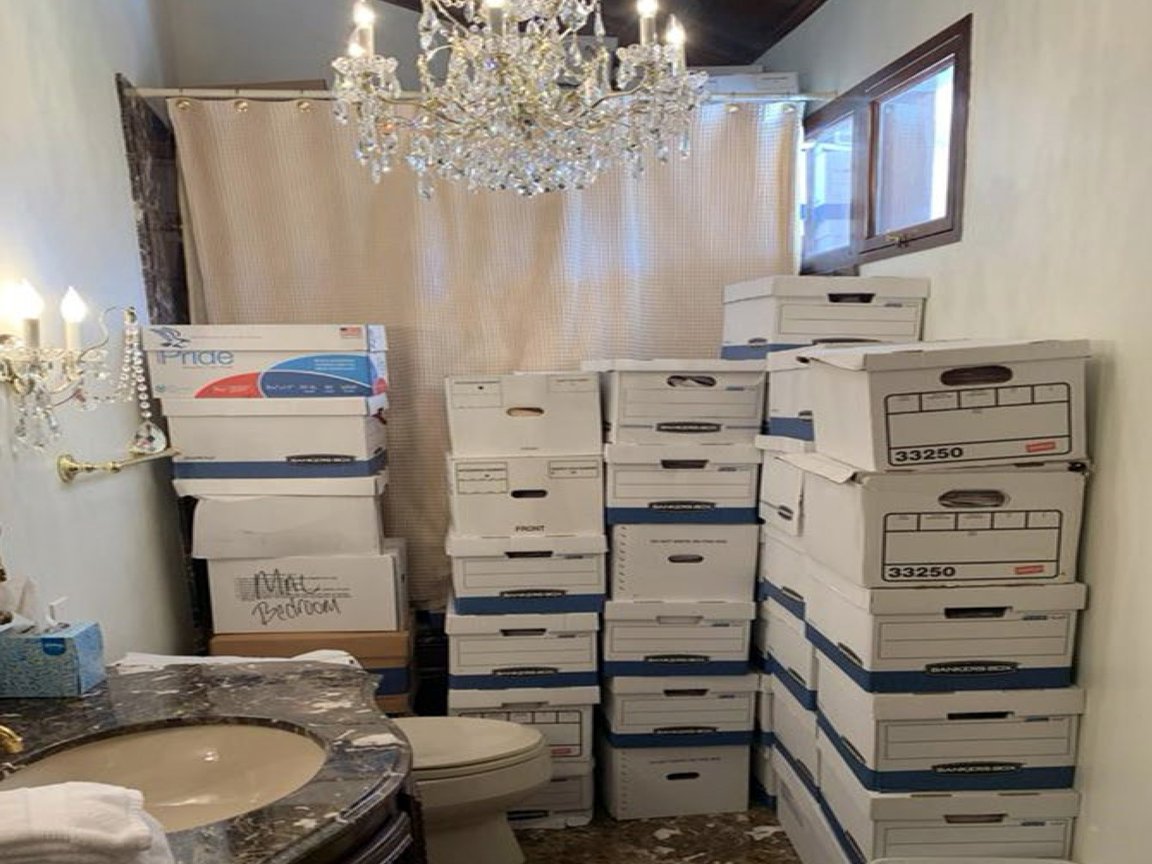 Several piles of storage boxes in a bathroom.