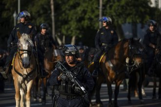 A photo of a law enforcement officer during an anti-immigration raid protest in Los Angeles.