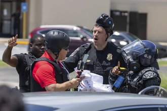 A photo of a reporter having a confrontation with police