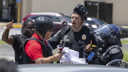 A photo of a reporter having a confrontation with police