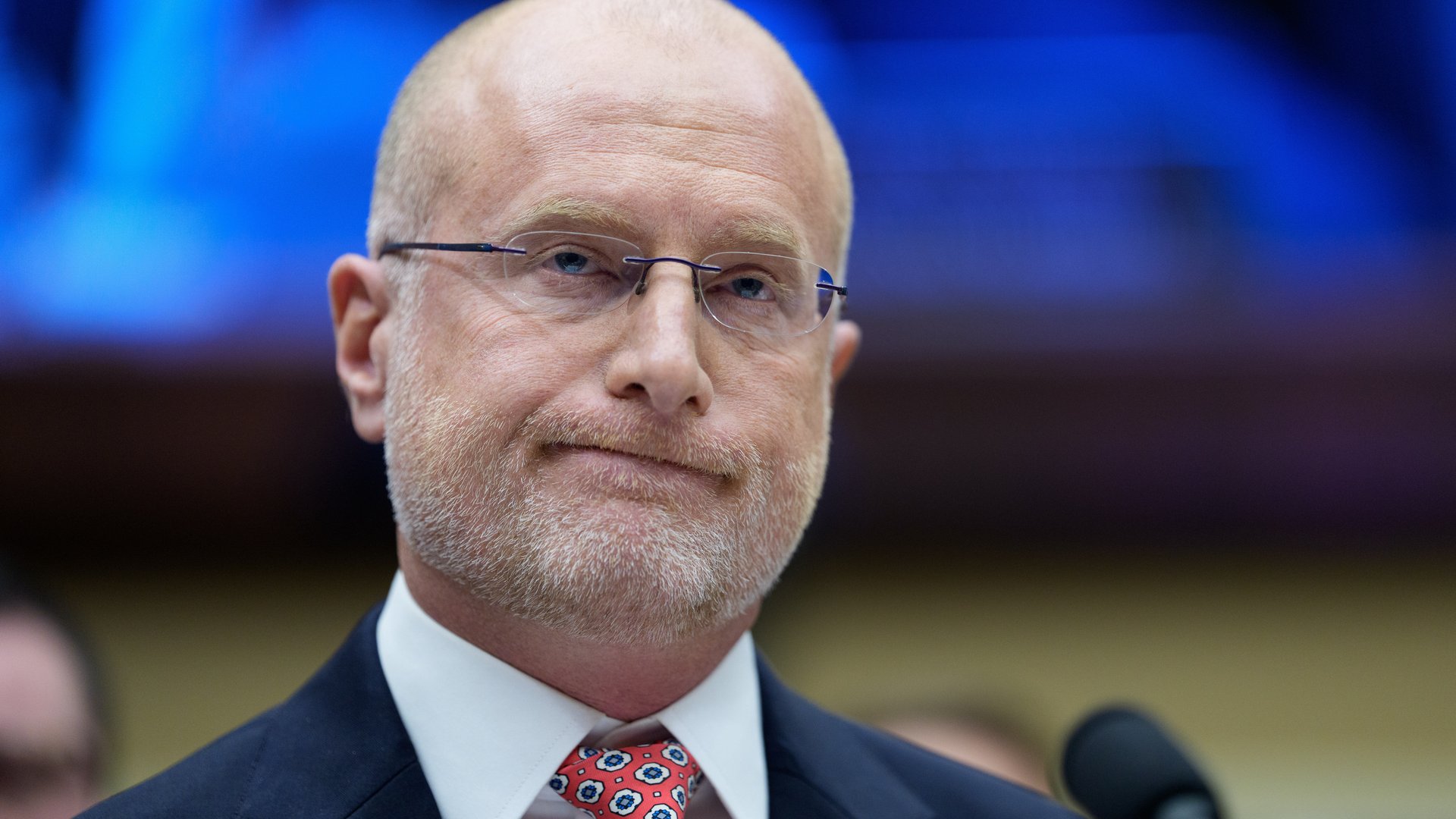 Brendan Carr, shown facing the camera from the shoulders up wearing a suit, with a half smile on his face.