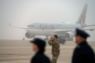 A Qatari airline plane sits on the tarmac as President Donald Trump boards Air Force One in February.