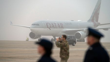 A Qatari airline plane sits on the tarmac as President Donald Trump boards Air Force One in February.