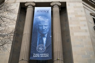 The Department of Justice building with a large Donald Trump banner with the slogan Make America Safe Again