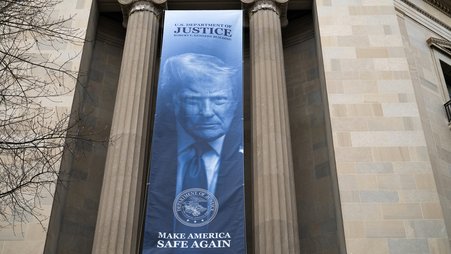 The Department of Justice building with a large Donald Trump banner with the slogan Make America Safe Again