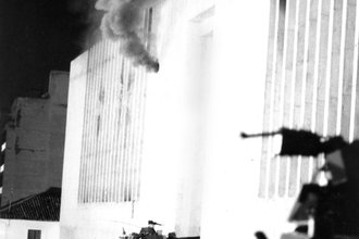 Smoke billows from a hole made by a cannon fired by an army armored car at the Palace of Justice in Bogota, Colombia, on Nov. 7, 1985