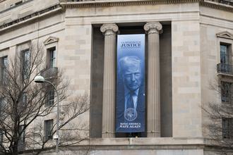 A banner of U.S. President Trump hangs from the U.S. Department of Justice building in Washington, D.C. in February 2026