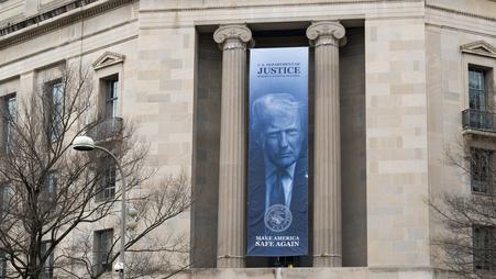 A banner of U.S. President Trump hangs from the U.S. Department of Justice building in Washington, D.C. in February 2026