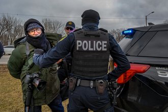 Freelance photojournalist Matthew Kaplan, at center left in green, was the first journalist known to be arrested this year, when he was detained covering an anti-deportation protest in Gary, Indiana, on Jan. 18, 2025.