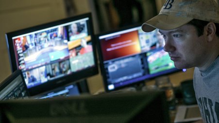 Journalist Tim Burke in front of a computer and two monitors