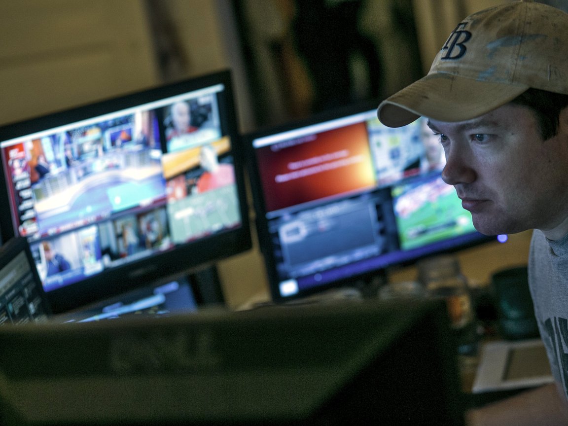 Journalist Tim Burke in front of a computer and two monitors