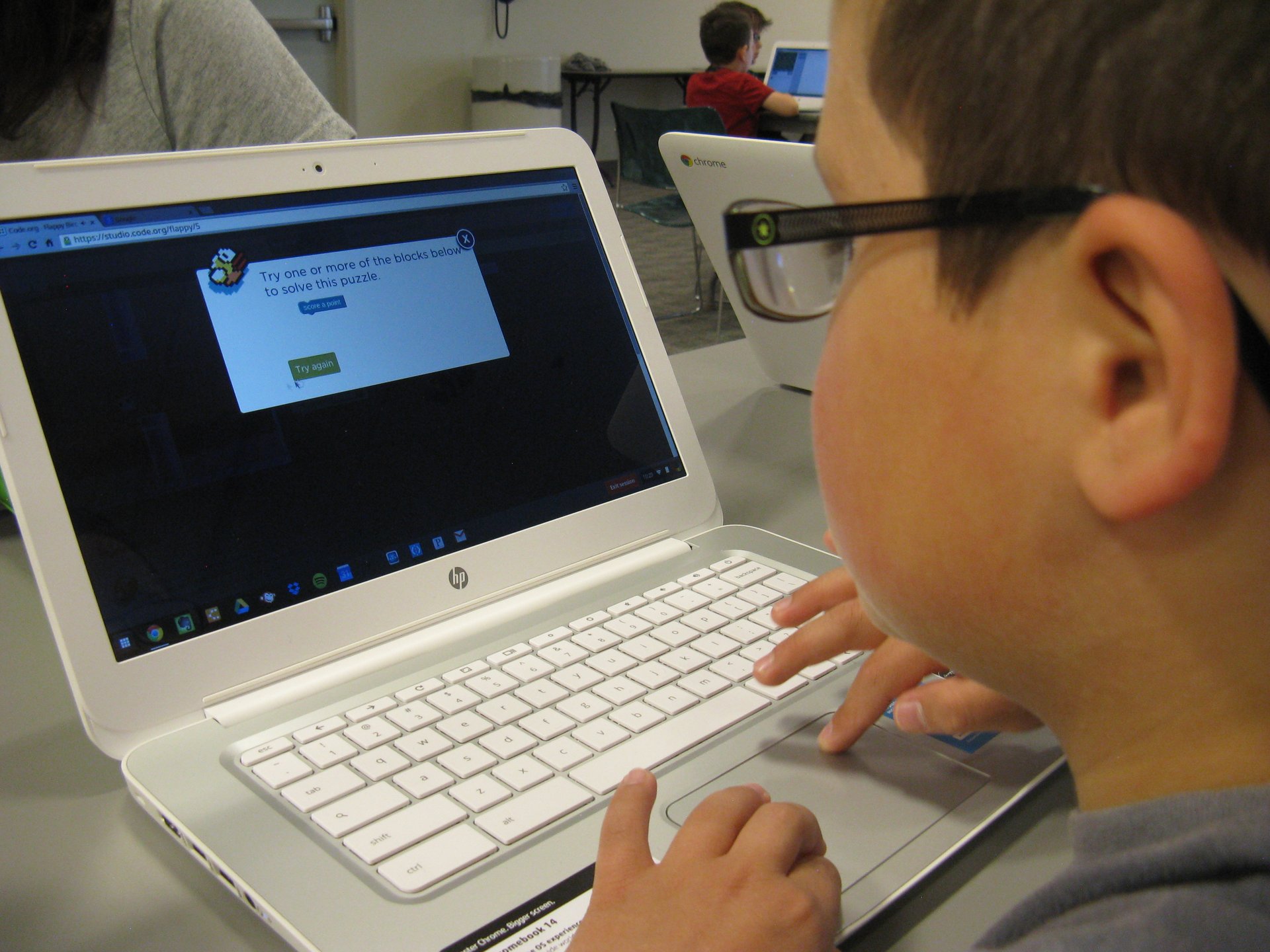 A child wearing glasses looks at a computer screen.
