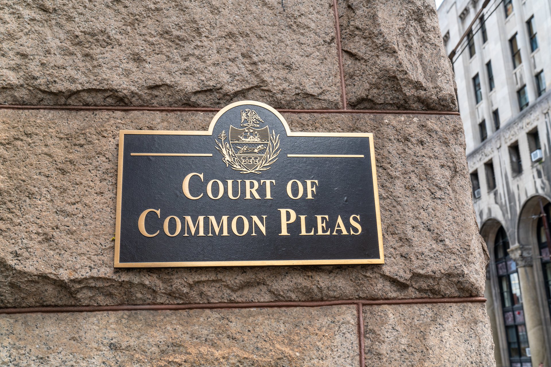 A black sign on a brown brick building reads "Court of Common Pleas"