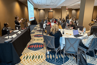 FPF’s Davis Erin Anderson, standing at left, presents at a national Education Writers Association meeting in May 2025.