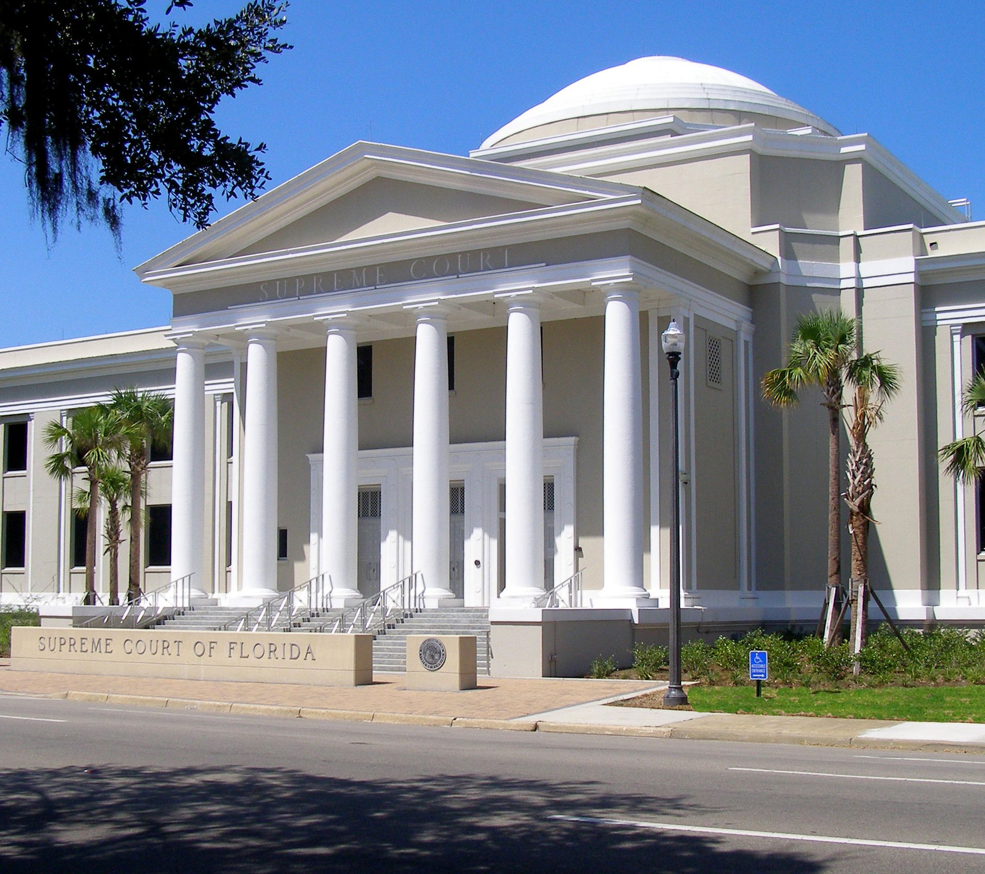 A white domed building with six columns and a concrete sign reading "Supreme Court of Florida"