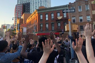 Protestors at a George Floyd action in Brooklyn raise their hands
