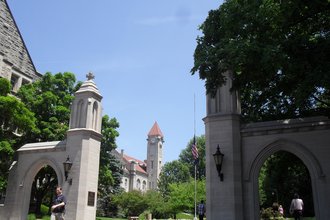 The Sample Gates at Indiana University. Stone gates frame a university building with a clock tower