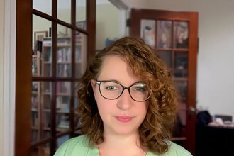 Reporter Stephanie Sugars in a light green shirt and glasses.
