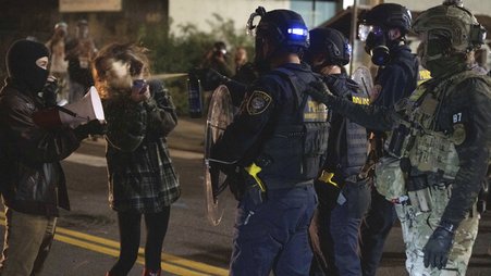 A Department of Homeland Security officer sprays a protester outside an Immigration and Customs Enforcement facility on Oct. 2 in Portland, Oregon.