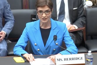 Catherine Herridge sits at a desk in Congress, speaking into a microphone.