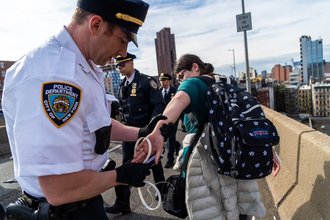 Independent reporter Katie Smith is detained by New York City Police Department officers on May 11, 2024, as she documented a pro-Palestinian protest on the Manhattan Bridge.