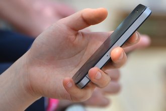 A hand holds a phone.