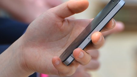 A hand holds a phone.