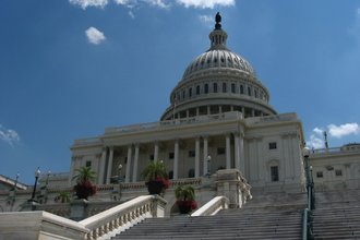 West face of the US Capitol Building before a blue sky with a few small clouds