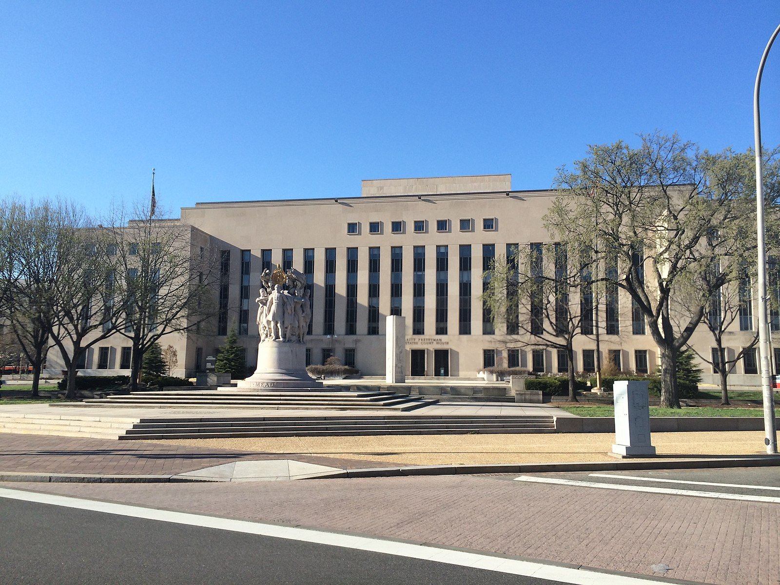 E. Barrett Prettyman U.S. Courthouse: A brown government building with a circle of figures carved in marble in front