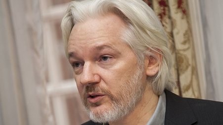Julian Assange's faces the camera, with his head turned slightly