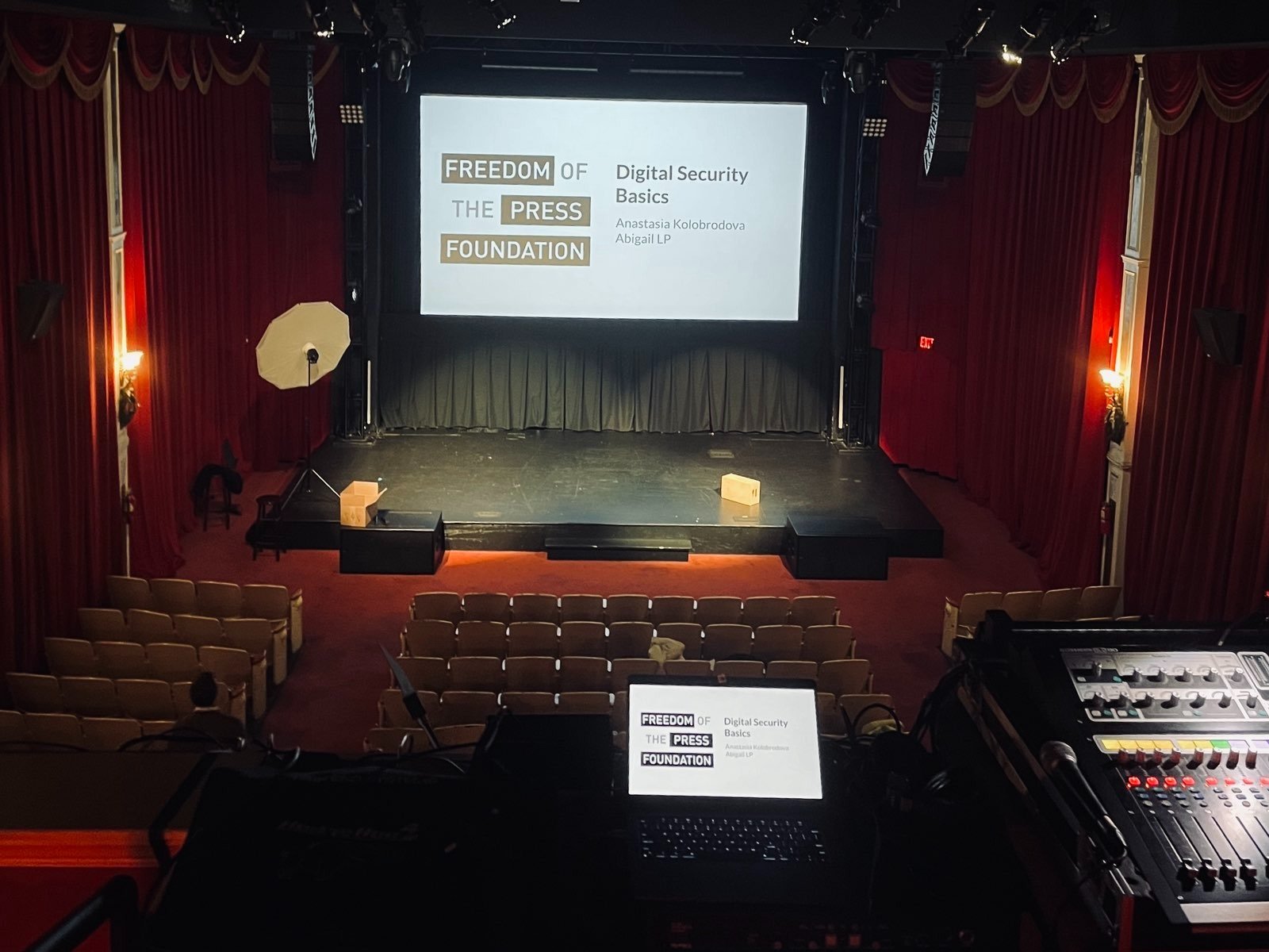 Photo of a theatre where a digital security training is being conducted, with the Freedom of the Press Foundation logo on the projector screen