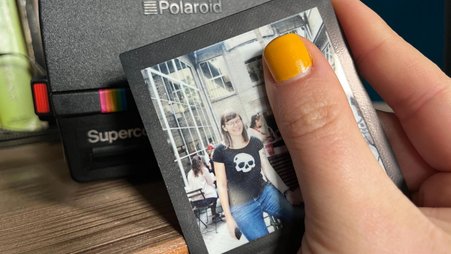 Header image of a Polaroid photo of the author, featuring a wide smile, with a Polaroid instant camera in the background.